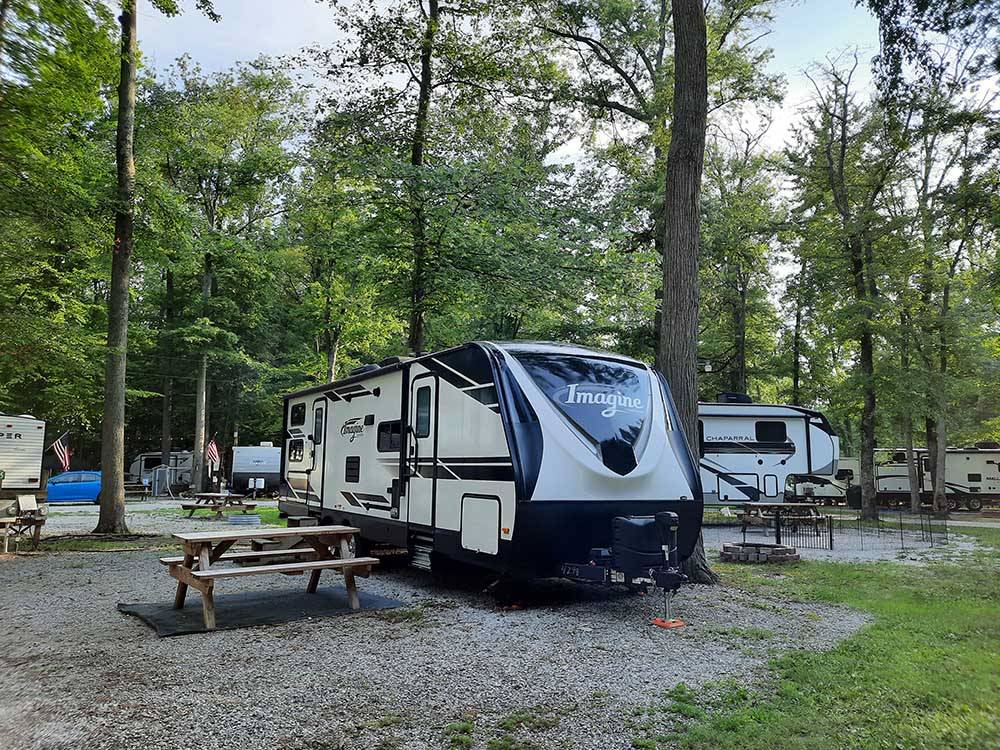 Travel trailer parked at campsite at COLUMBUS WOODS-N-WATERS KAMPGROUND