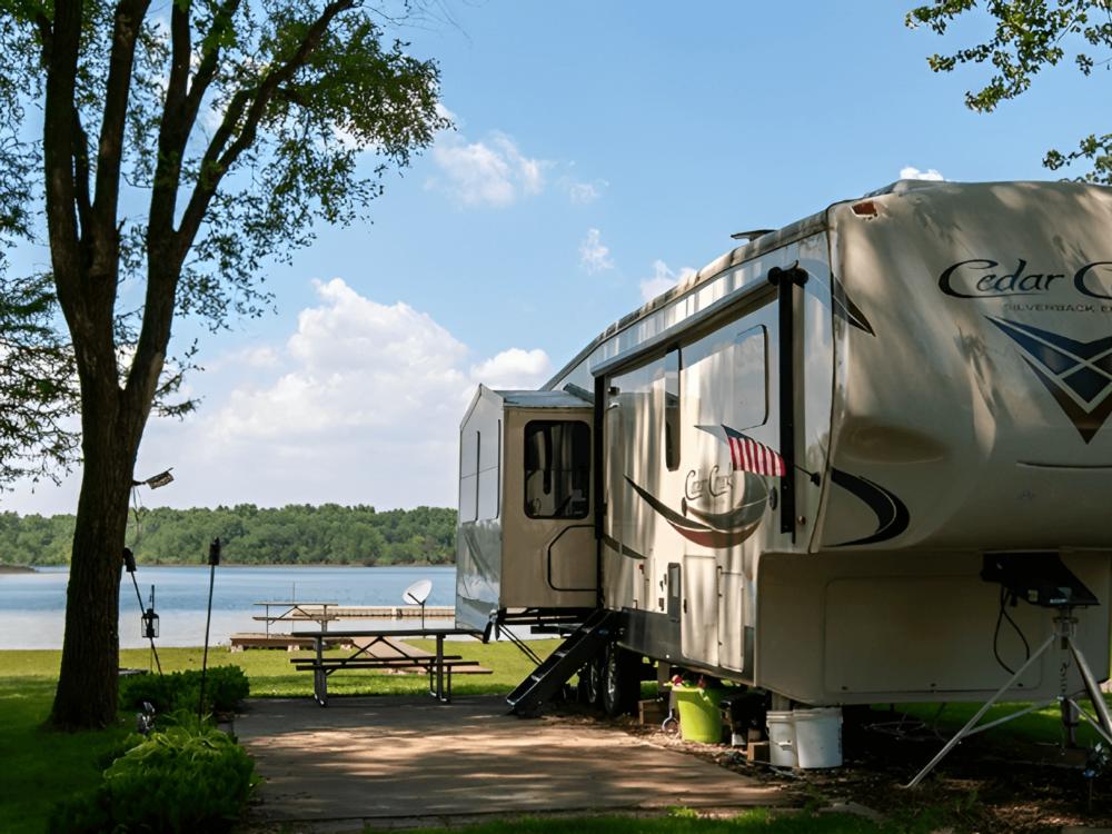 An RV parked in a site by the lake