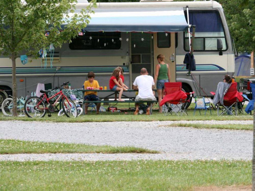 A family hanging out at their RV site at Indiana Beach Campground