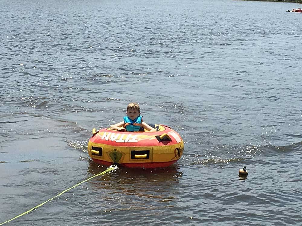 Child being towed in a tube  at LAKE GASTON AMERICAMPS