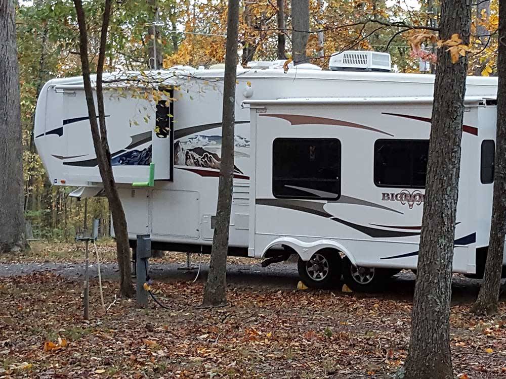 A fifth wheel trailer under trees at GREENVILLE FARM FAMILY CAMPGROUND