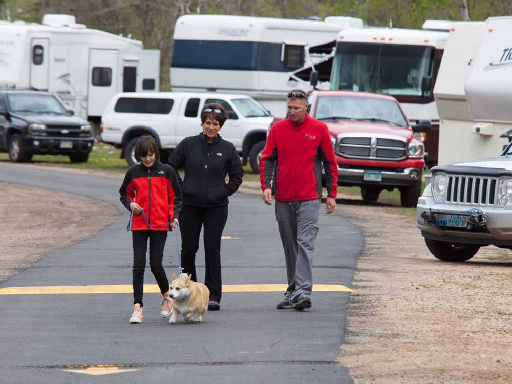 A family walking a dog at MANOR RV PARK