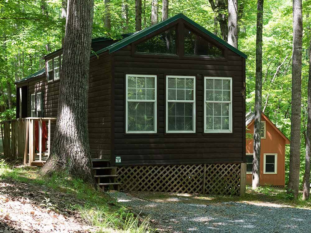 Log cabin in shaded area at MISTY MOUNTAIN CAMP RESORT