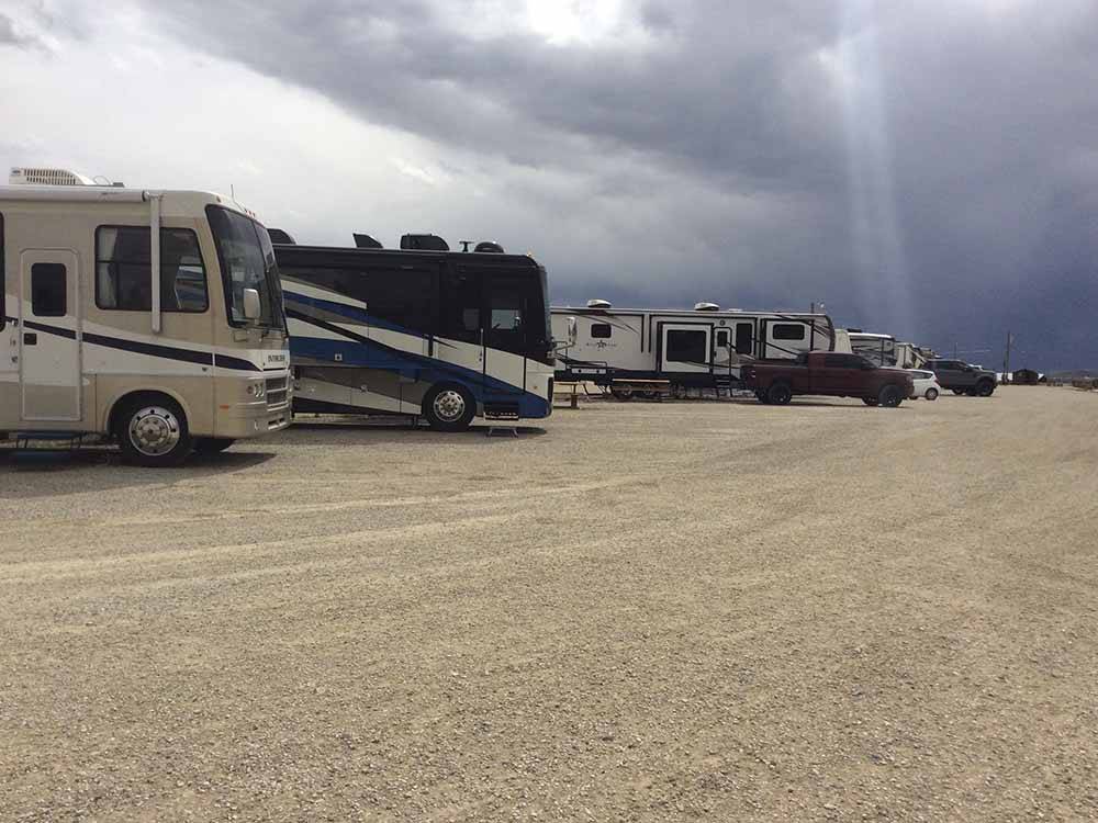 A row of motorhomes in gravel at WESTERN HILLS CAMPGROUND