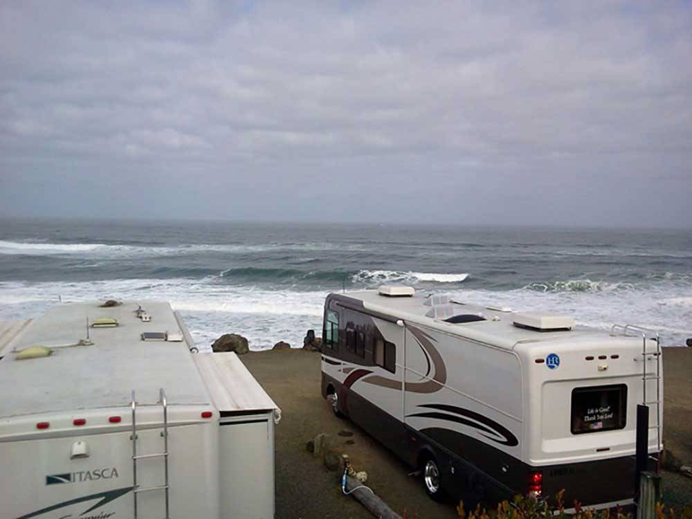 RVs camping at ocean with crashing waves at SEA & SAND RV PARK