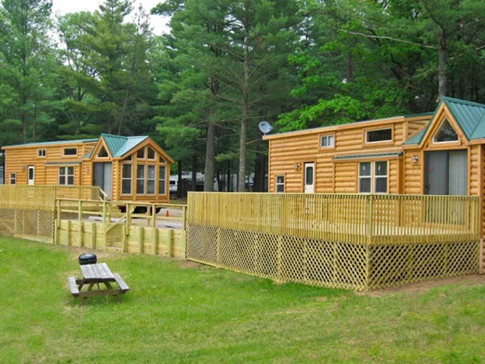 Grass area with cabins and trees at LAKE OF THE WOODS CAMPGROUND
