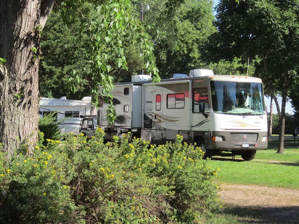 RVs and truck parked with yellow flowers in foreground at HOLIDAY RV PARK & CAMPGROUND