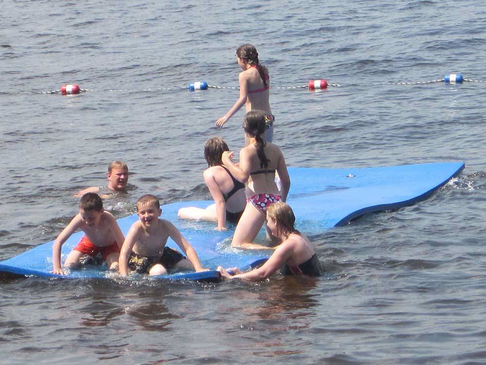 Kids swimming in lake at LAKE DUBAY SHORES CAMPGROUND