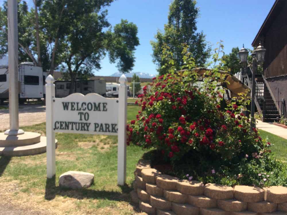 The welcome sign next to a flower bin at CENTURY RV PARK & CAMPGROUND