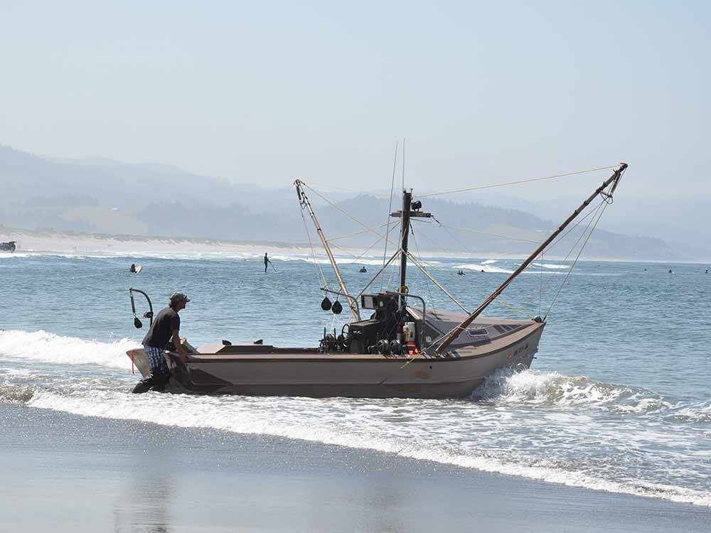 A fishing boat that is washed up on the shoreline at CAPE KIWANDA RV RESORT  MARKETPLACE