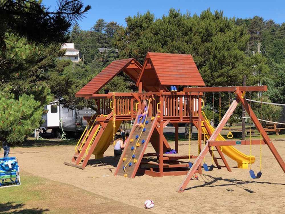 The wooden playground equipment in the sand at CAPE KIWANDA RV RESORT & MARKETPLACE