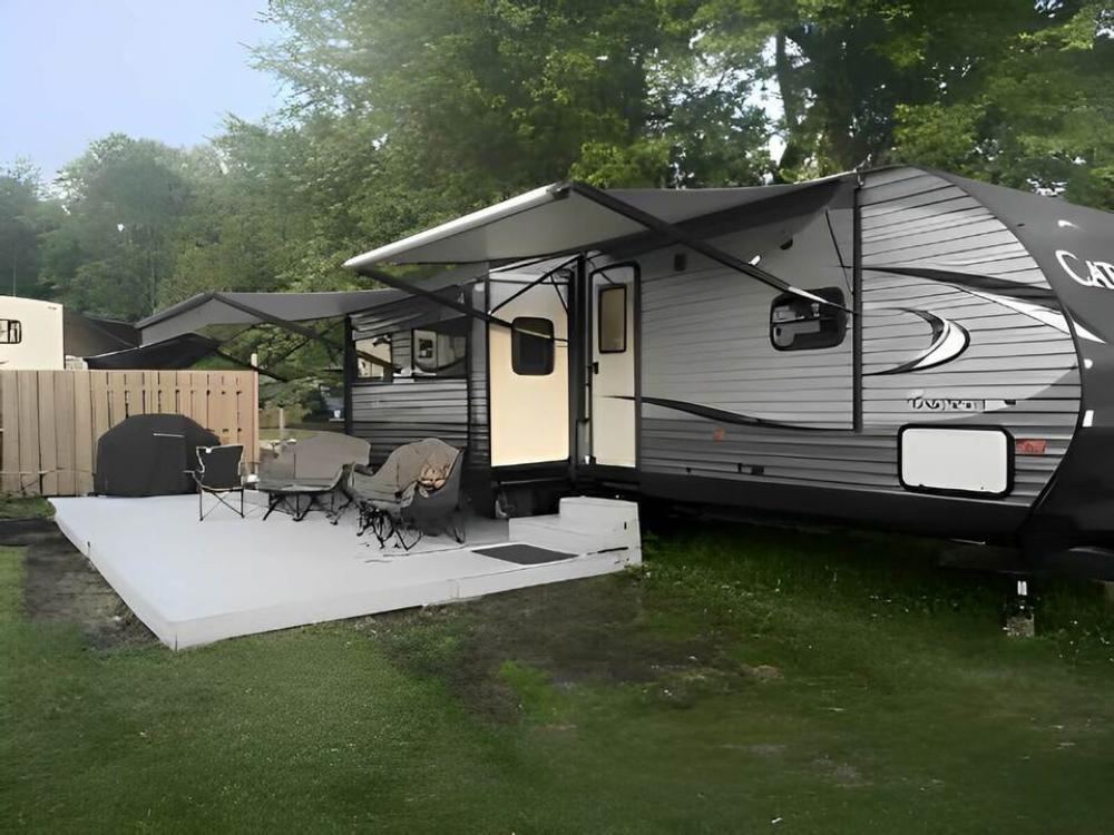 Travel trailer with awnings over seating at Hide-A-Way Campground