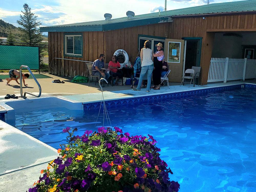 Guest sitting near the pool at MEADOWS OF SAN JUAN RV RESORT