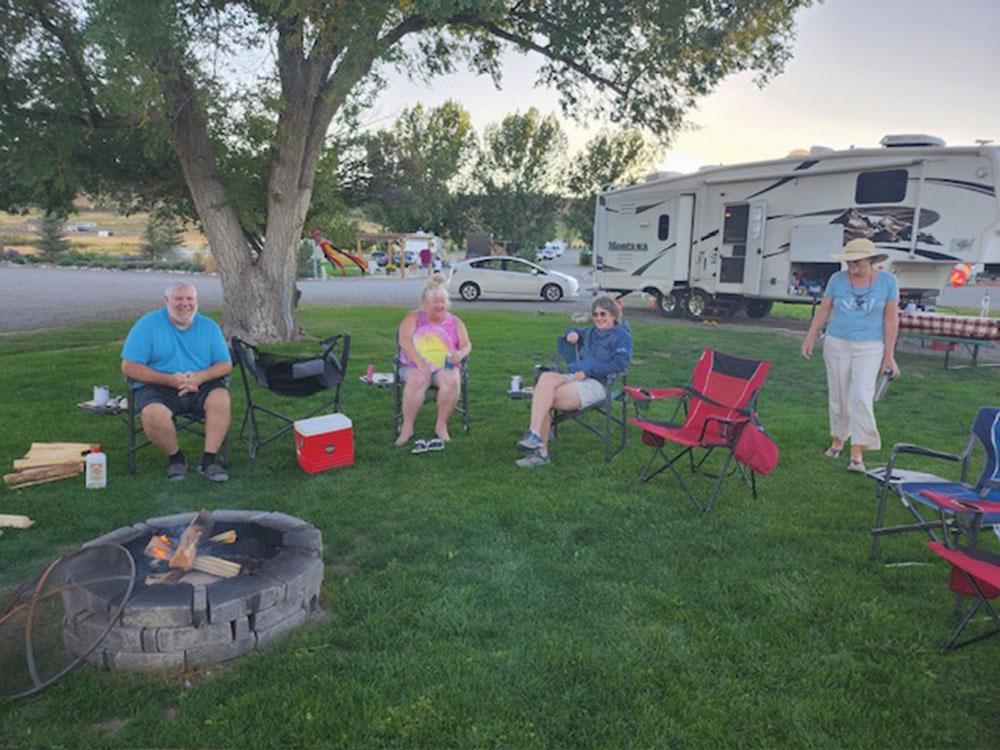 People around a fire pit at MEADOWS OF SAN JUAN RV RESORT