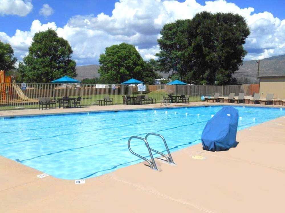 Swimming pool with outdoor seating at WHITE SANDS MANUFACTURED HOME AND RV COMMUNITY