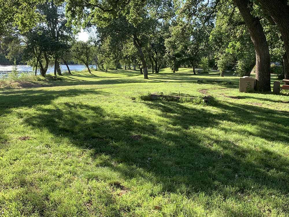A large grassy area with trees at JGW RV PARK