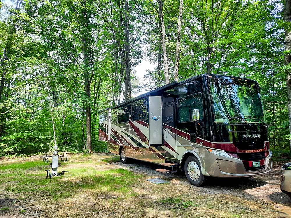 A motorhome in a dirt site at KALKASKA RV PARK & CAMPGROUND