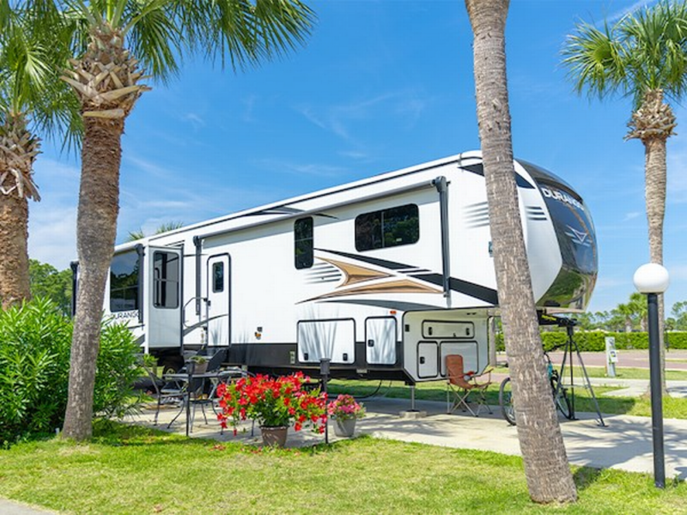 Trailer by trees at Rainbow Village Zephyrhills Sun RV