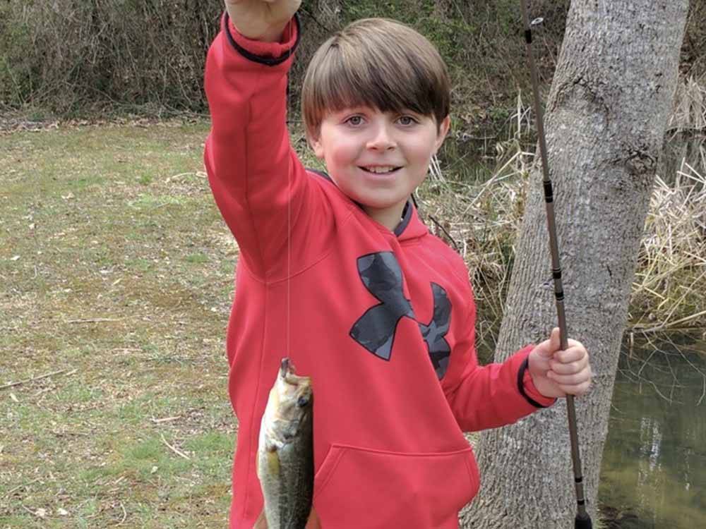 A kid holding a fish at CAMPFIRE LODGINGS