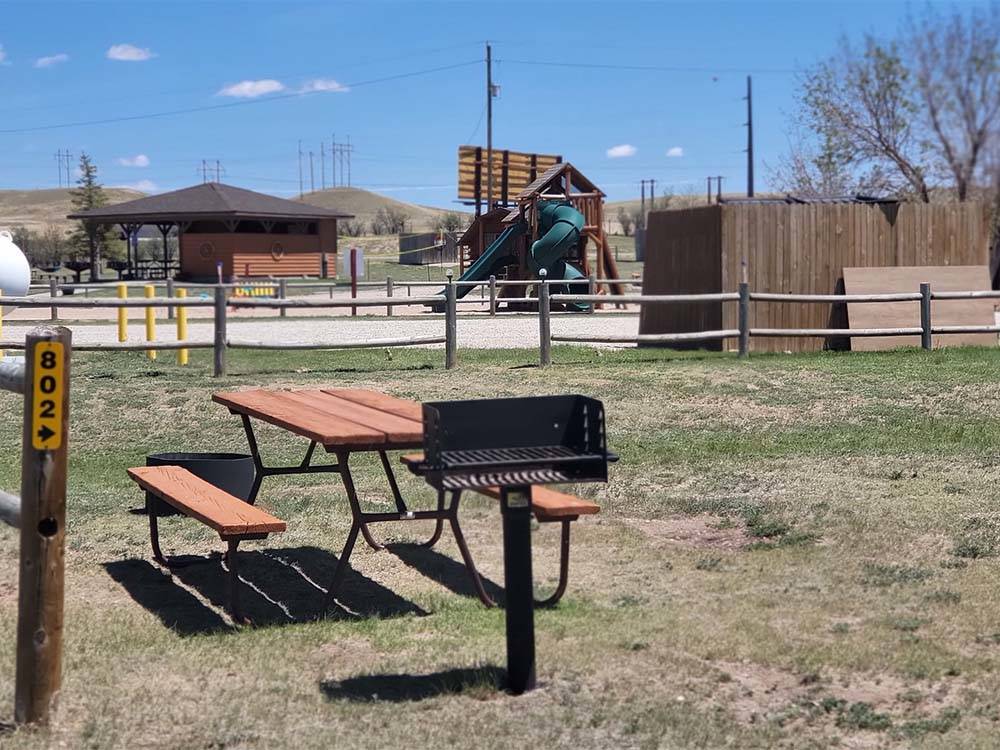 A picnic bench and fire pit at CHEYENNE RV RESORT BY RJOURNEY