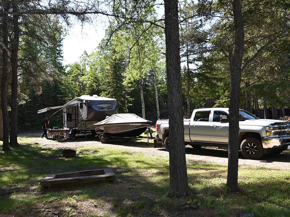 Truck, boat and camper in campsite at WAWA RV RESORT & CAMPGROUND
