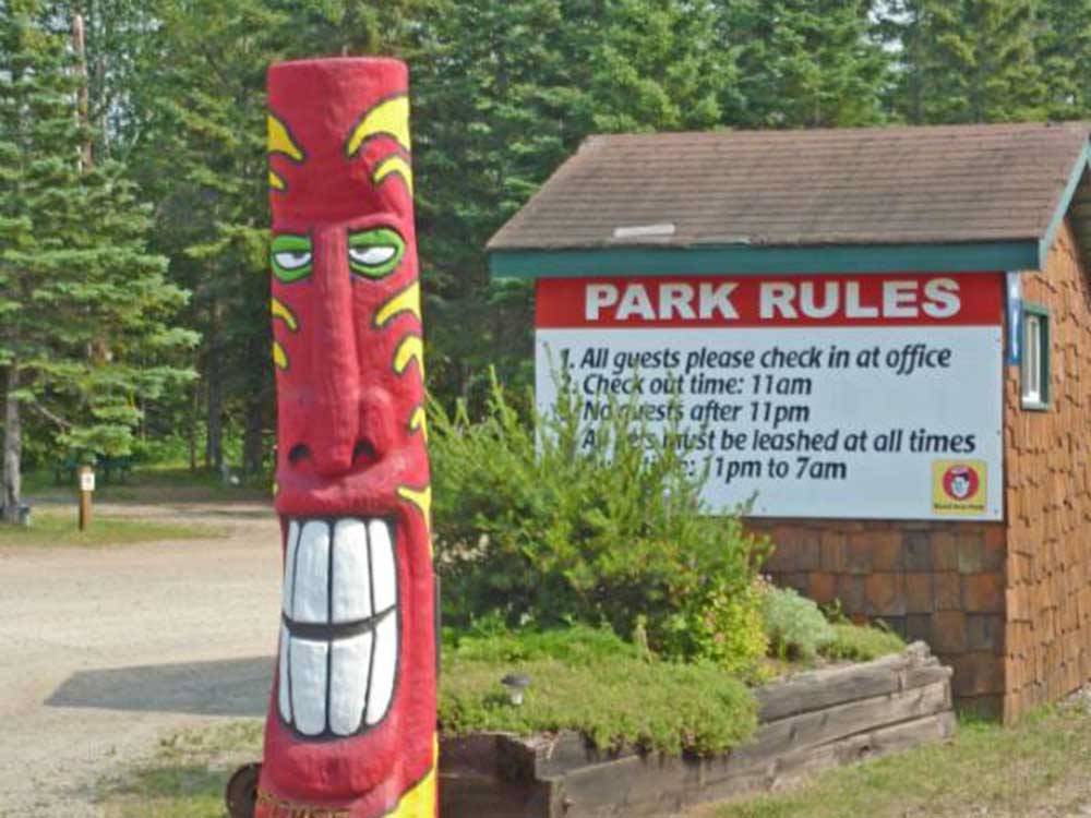 Red totem pole in front of sign listing Park Rules at WAWA RV RESORT & CAMPGROUND