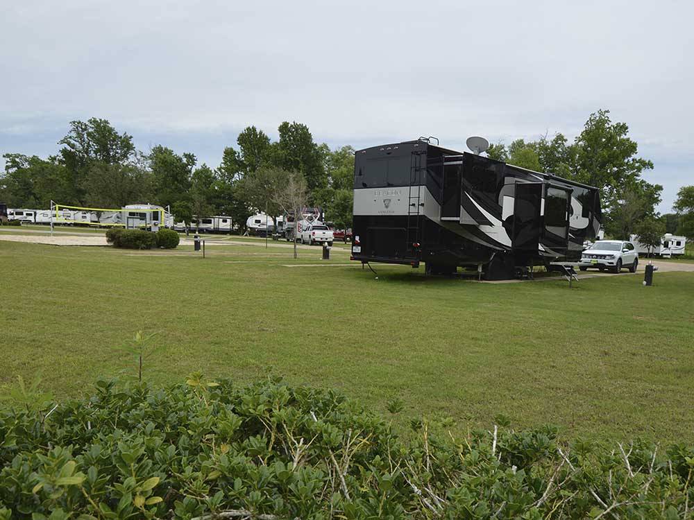 A fifth wheel parked next to the volleyball court at BUSHMAN'S RV PARK