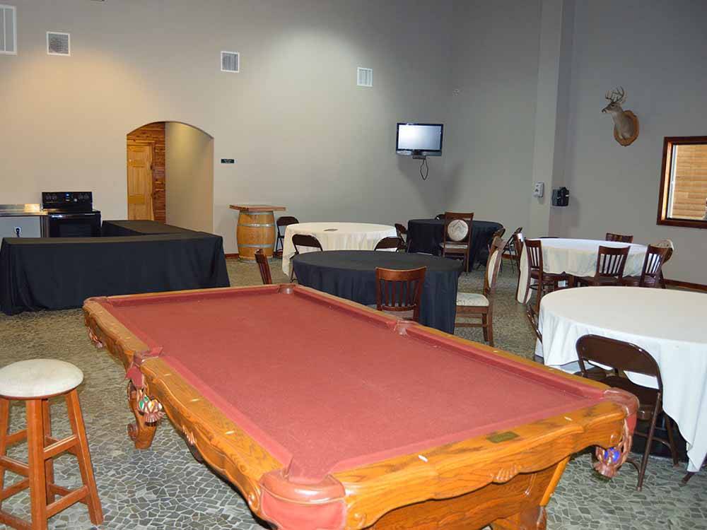 A red pool table sits among tables at BUSHMAN'S RV PARK