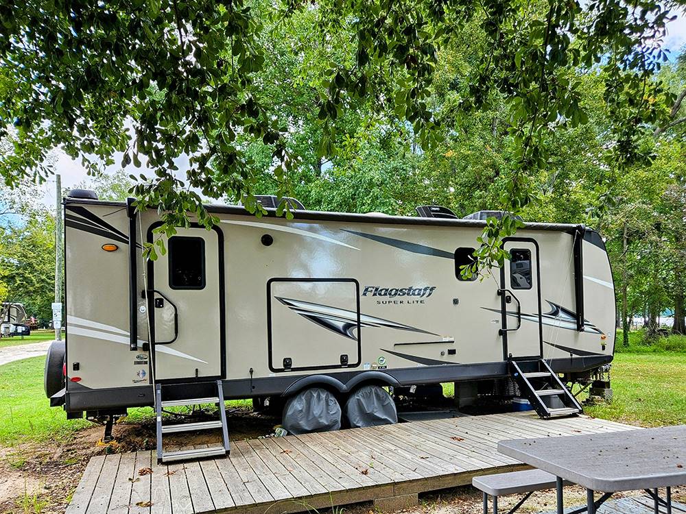 A tan travel trailer parked at a site at Taw Caw Campground & Marina