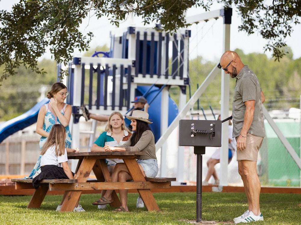 A family sits at a picnic table at Bayberry RV Park