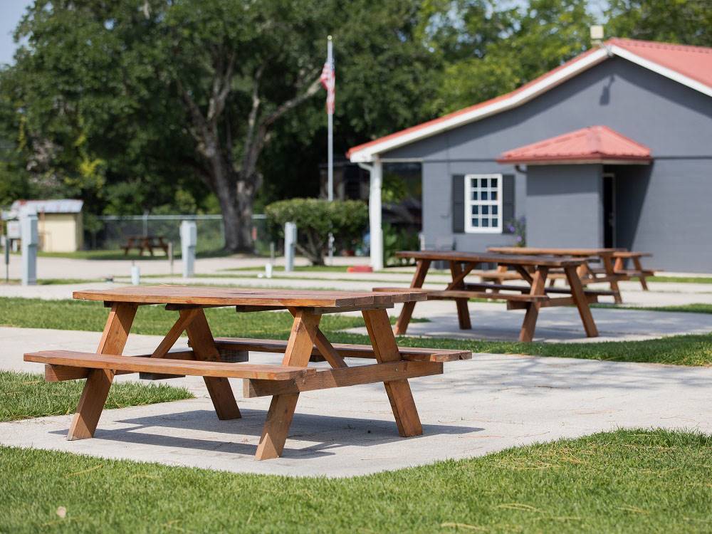 Picnic tables at paved sites surrounded by grass at Bayberry RV Park