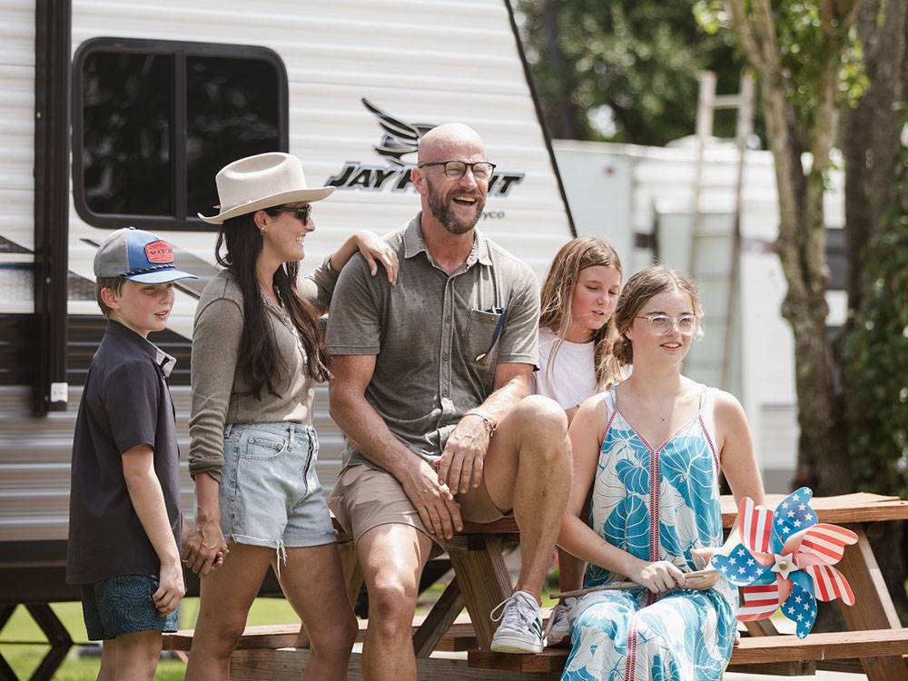 A family sitting at a picnic table at Bayberry RV Park