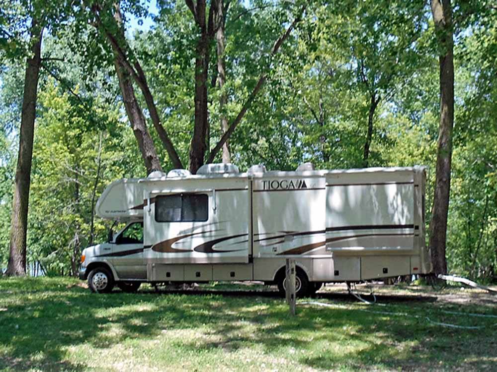 A class C motorhome in A RV site under trees at MILLPOINT RV PARK