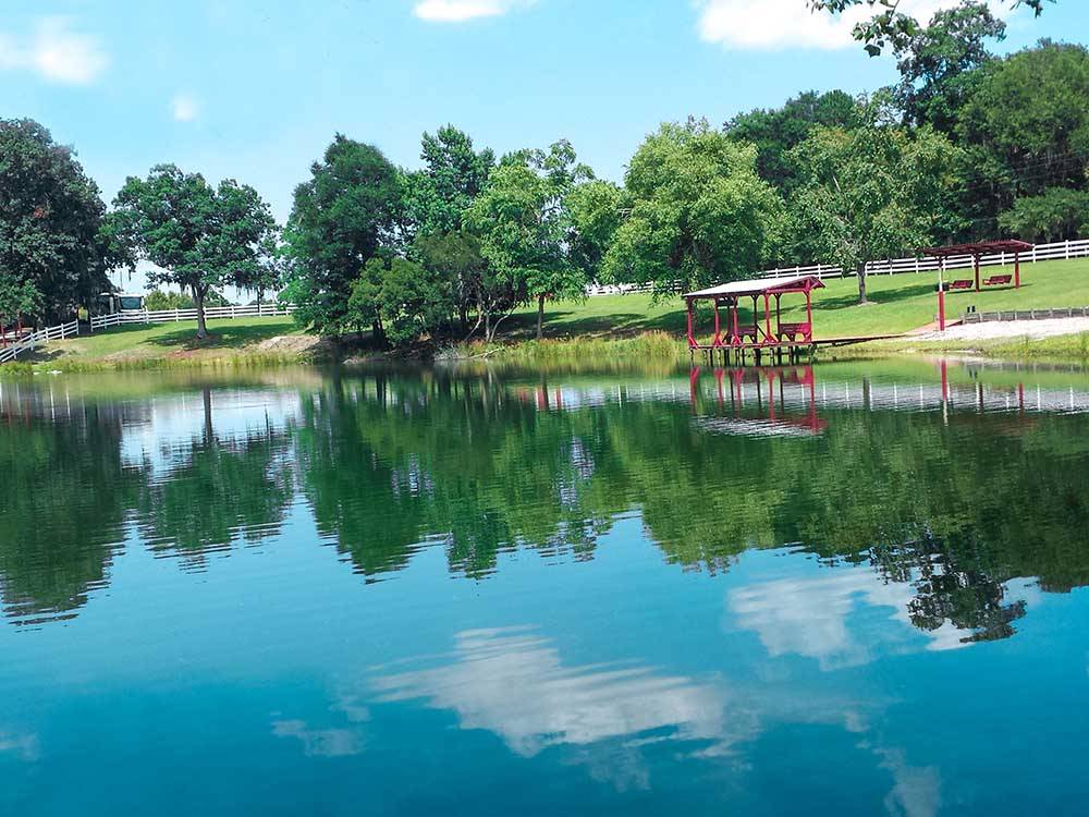 Two covered benches on the pier at the lake at RED GATE FARMS - RV RESORT