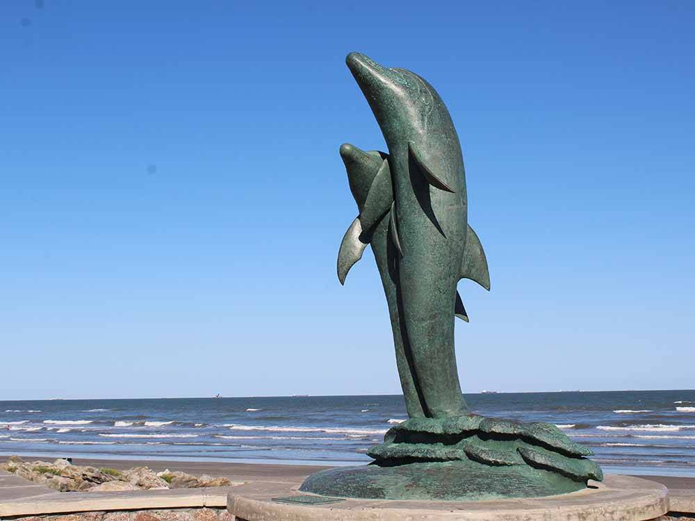 Dolphin statue next to the ocean at DELLANERA RV PARK