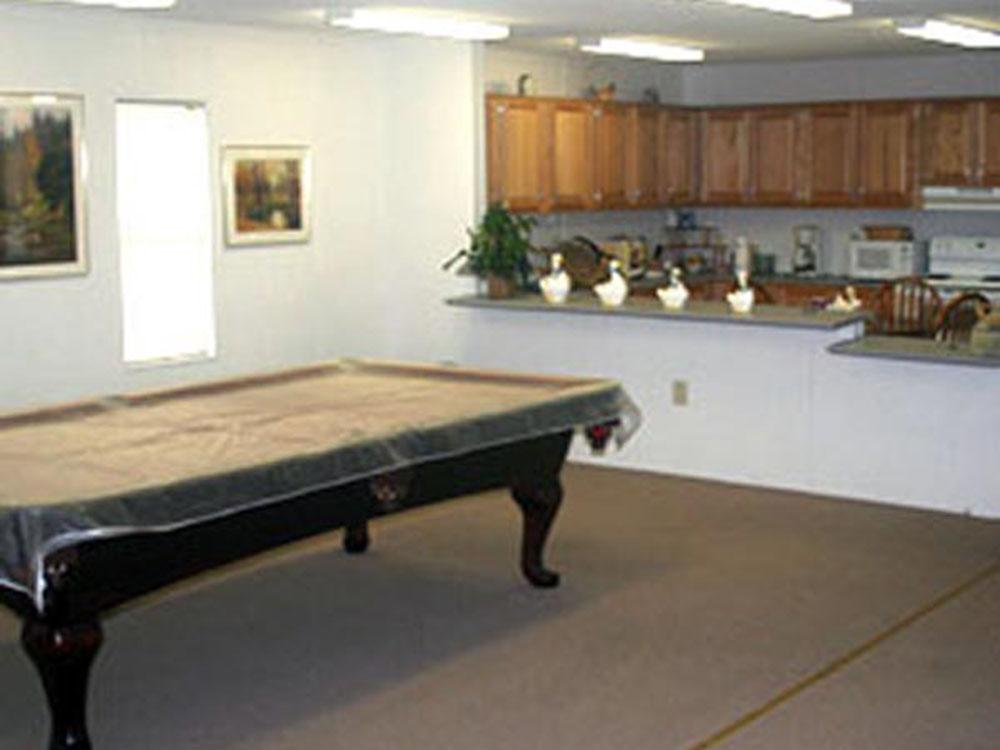 Indoor rec hall with kitchen and billiard table at SWEET GUM MOBILE HOME AND RV COMMUNITY