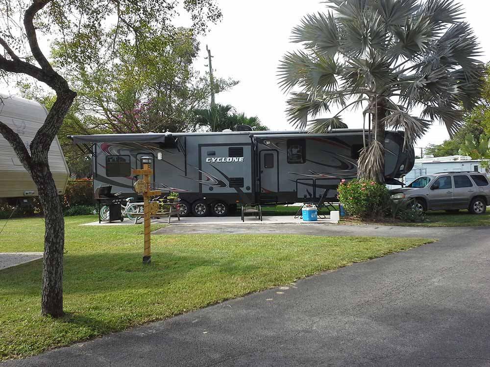 Trailer with BBQ pit and picnic table at BOARDWALK RV RESORT