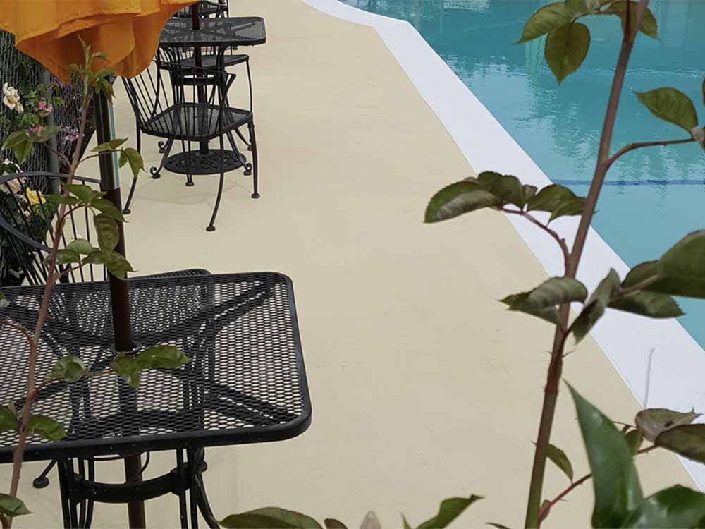 A seating area by the swimming pool at FRESNO MOBILE HOME & RV PARK