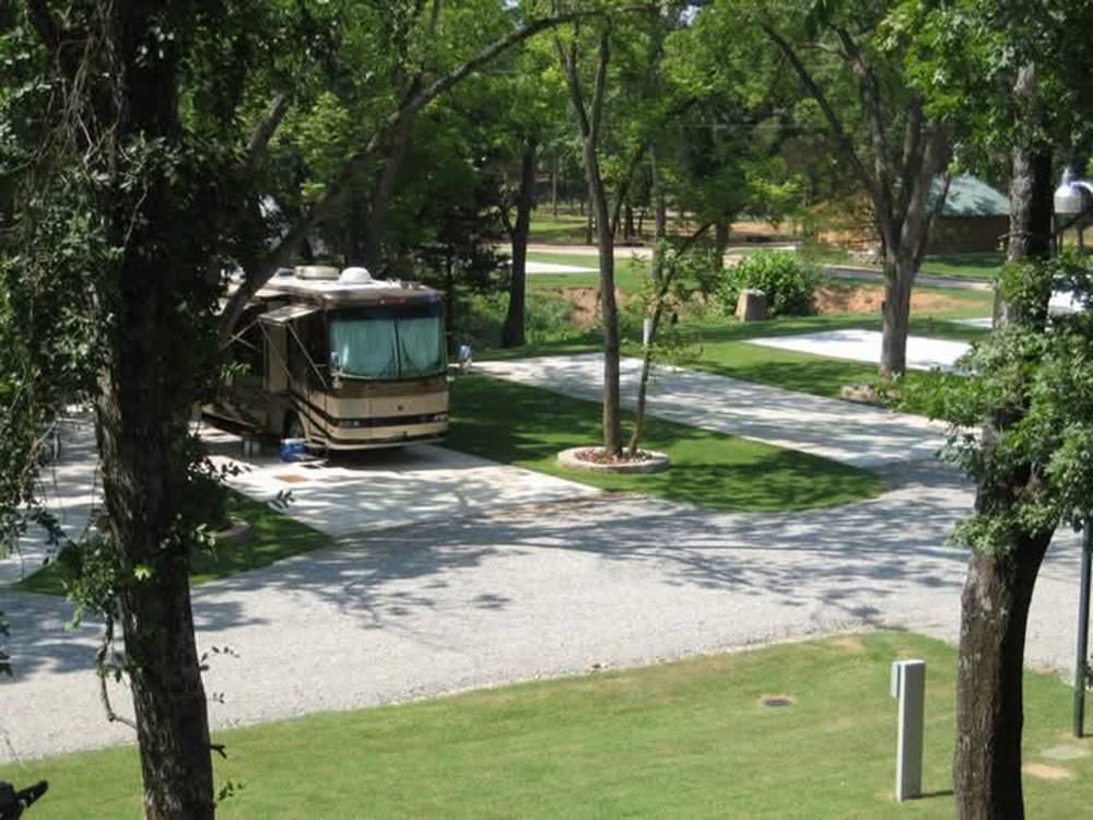 An RV parked at a shaded site