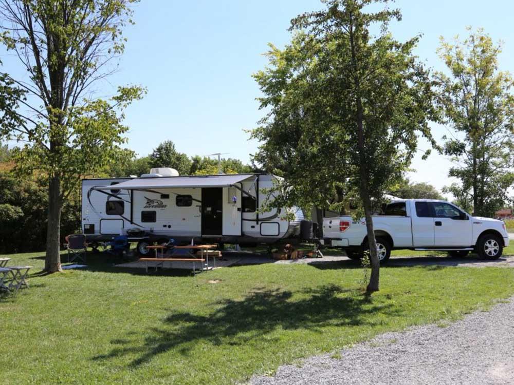 Travel trailer with white pickup truck in campsite at HTR NIAGARA