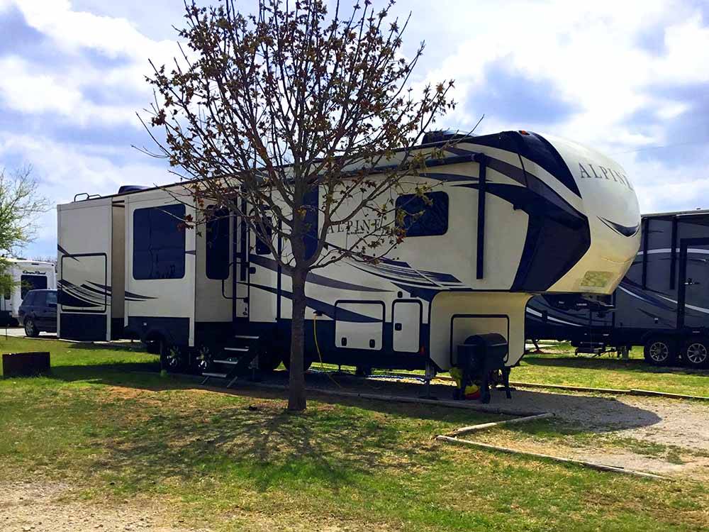 A fifth wheel trailer in a RV site at HOOVES N' WHEELS RV PARK & HORSE MOTEL