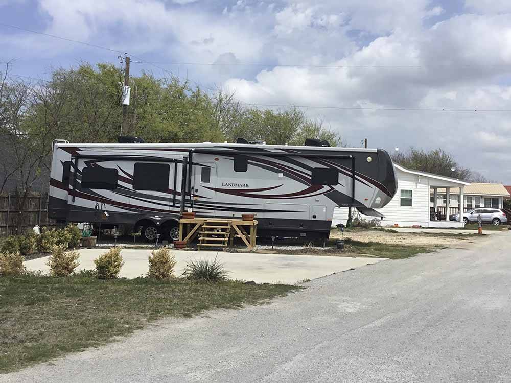 A fifth wheel in a back in RV site at HOOVES N' WHEELS RV PARK & HORSE MOTEL