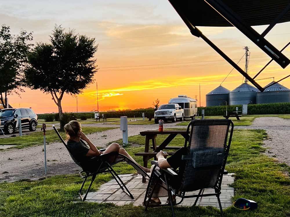 A couple sitting by a site a dusk at KEARNEY RV PARK & CAMPGROUND