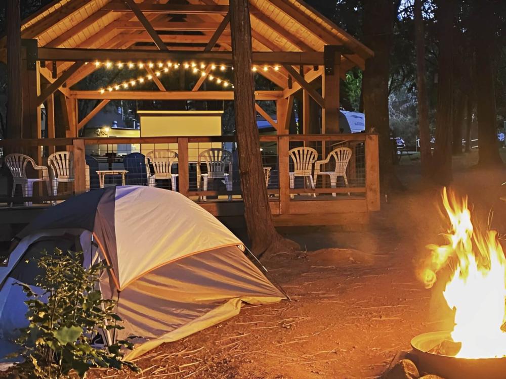 Campfire next to a tent and a pavilion