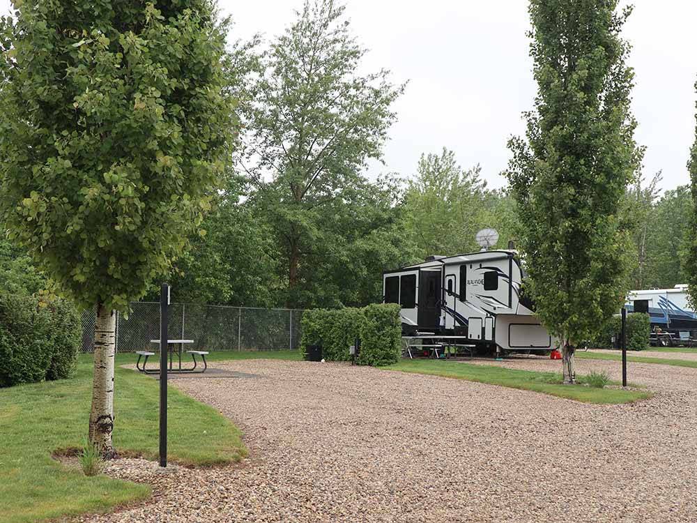 A back in gravel RV site at CAMP 'N CLASS RV PARK