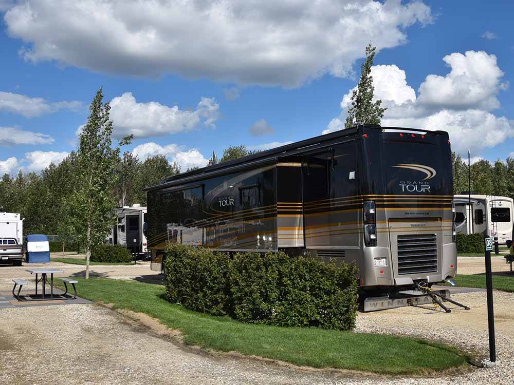 A motorhome parked in a gravel site at CAMP 'N CLASS RV PARK
