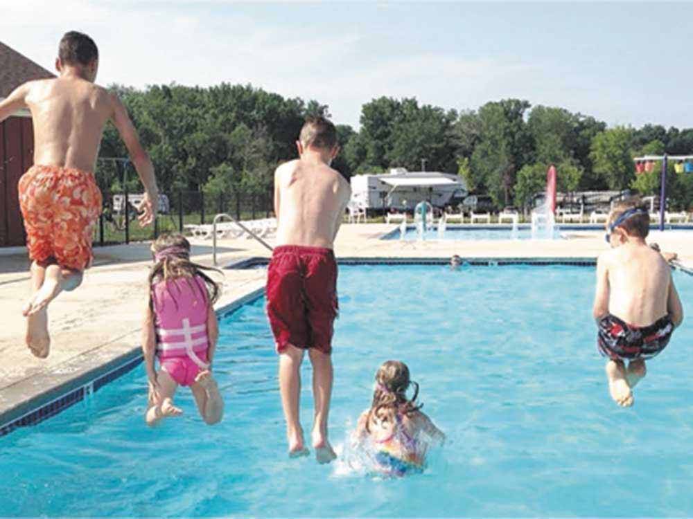 A group of kids jumping into the pool at CAMP TURKEYVILLE RV RESORT