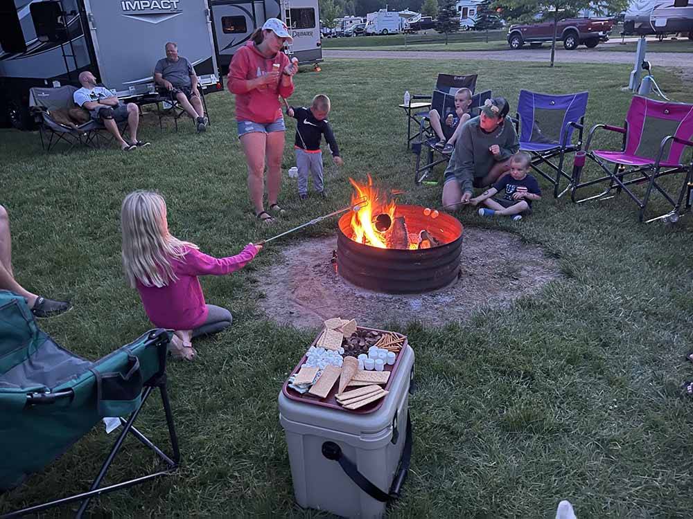 A girl roasting a marshmallow over a fire at CAMP TURKEYVILLE RV RESORT