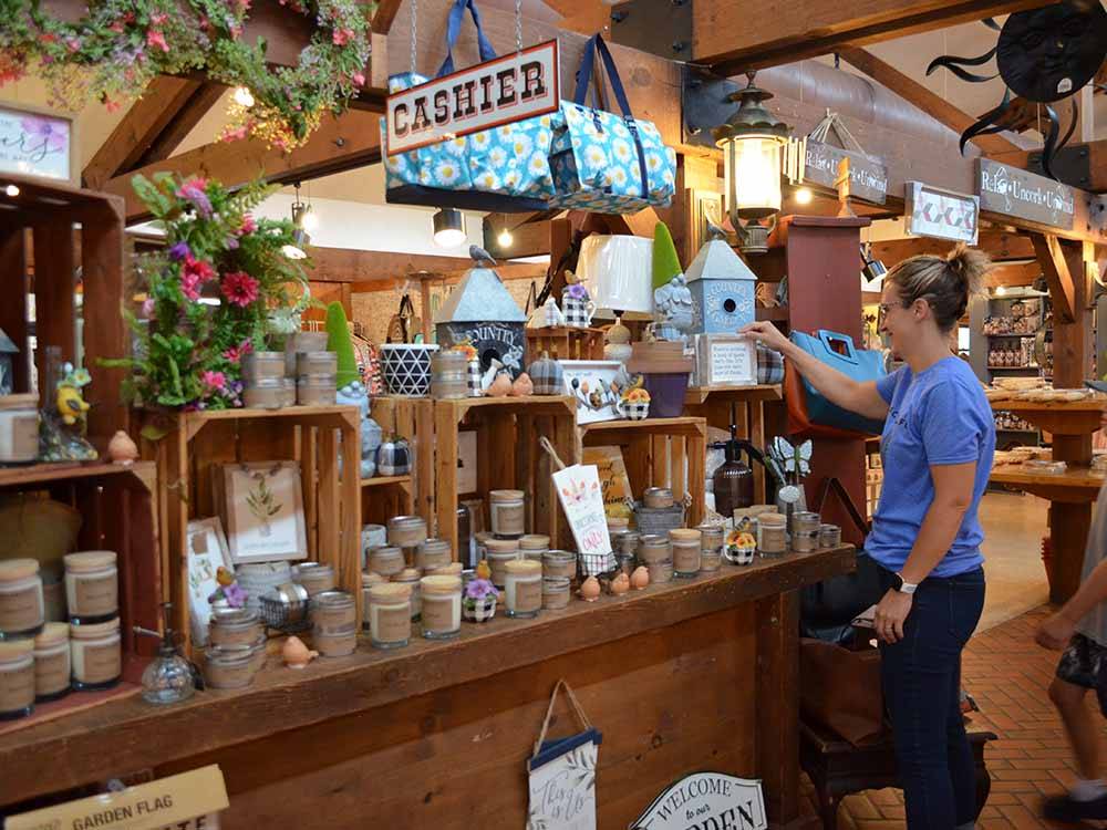 A woman shopping for candles in the general store at CAMP TURKEYVILLE RV RESORT