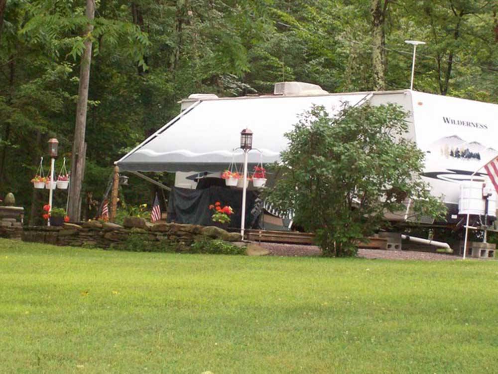 A travel trailer next to the grass at WHISPERING PINES CAMPING ESTATES